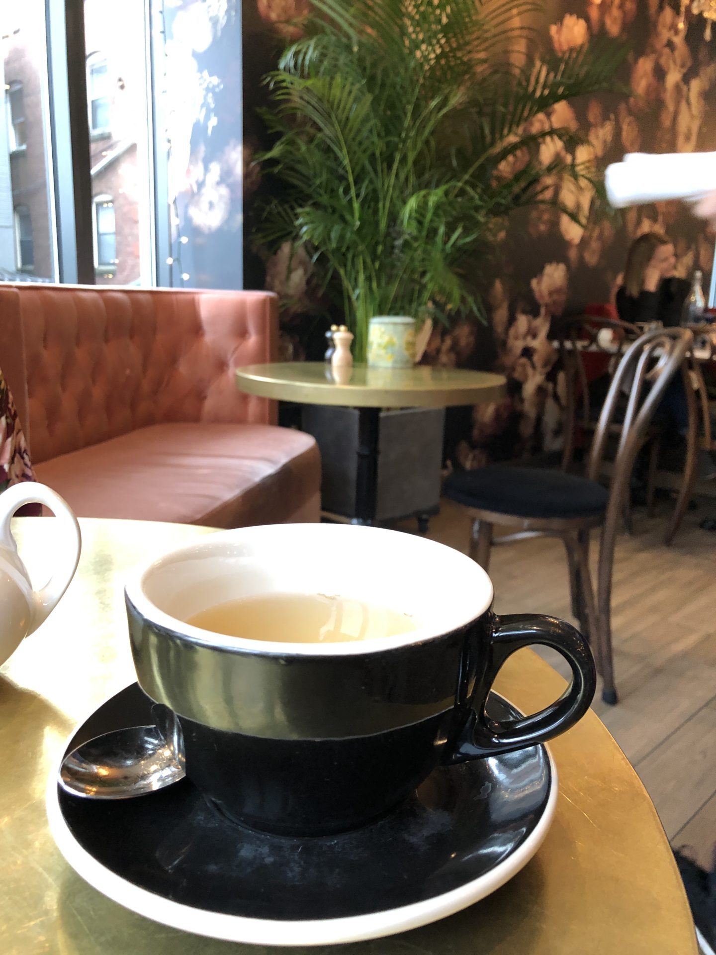 black teacup in cafe with pink couch