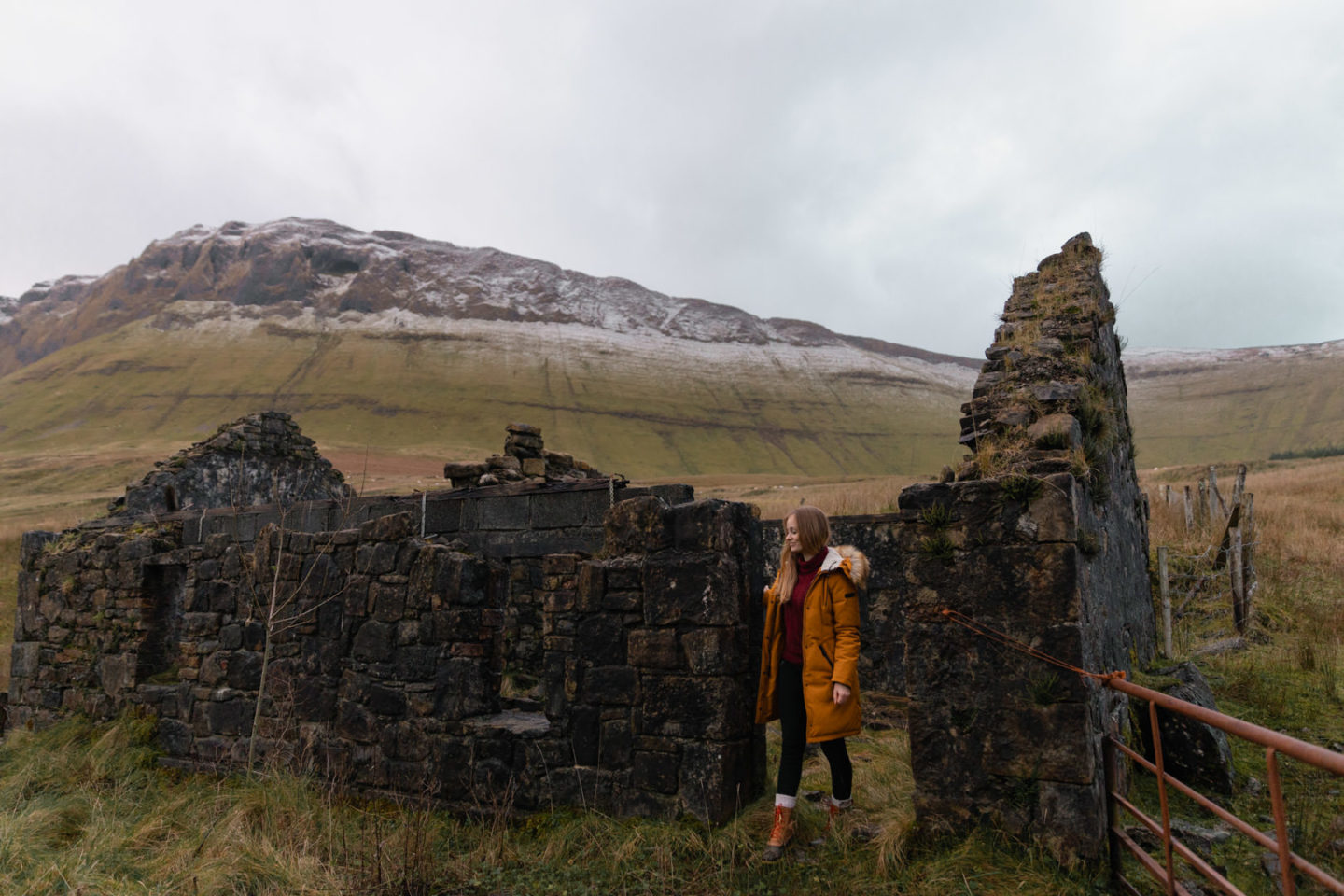 girl walking through irish house ruins